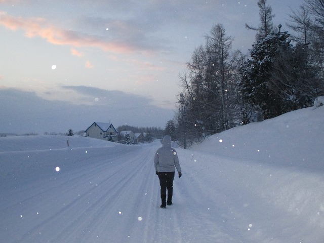 雪道を歩く後ろ姿の女性